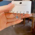 Detailansicht des silbernen süßen Katzen- und Fischgräten-Mehrstück-Ohrringsets auf Displaykarte. - Kleines Katzenpfoten Kettenset (51#) / Silber