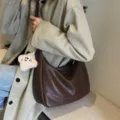 Borsa a tracolla in pelle marrone da donna, elegante hobo bag con tracolla larga e ciondolo. - Caffè