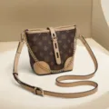 Elegante borsa a secchiello marrone con tracolla in pelle chic e splendida catena dorata. - Caffè