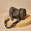 Borsa a tracolla cilindrica in pelle marrone con motivo intrecciato e cinturino a catena. - Caffè