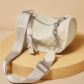 Chic beige leather barrel shoulder bag with wide fabric strap and stylish chain detail. - White