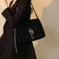 Elegante borsa a tracolla da donna in camoscio nero con fibbia dorata e cinturino. - Nero