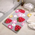 Vista detallada de la suave alfombra de baño gris con bonitos diseños copetudos de fresas. - 45*65cm / Gris
