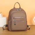 Detailed view of casual women's backpack, featuring multi-zipper pockets and stylish metal charms. - Khaki
