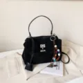 Schwarze Wildleder Handtasche für Damen, schicke Tasche mit Metallverschluss und Perlenanhänger. - Schwarz Mit Anhänger