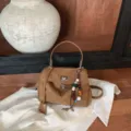 Braune Wildleder Handtasche, elegante Schultertasche mit schickem Perlenanhang für Frauen. - Braun mit Anhänger