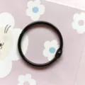 Gros plan détaillé d'un anneau relieur en métal noir, idéal pour les loisirs créatifs. - Anneaux de cartes noirs 45 mm