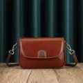Classic brown leather shoulder bag detail shot showing retro flap design and hardware. - Coffee