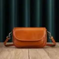 Detailed view of the brown leather shoulder bag showcasing fine stitching texture and hardware. - Sunset Yellow