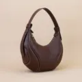Brown leather crescent shoulder bag for women, stylish hobo commute handbag with white stitching. - Coffee