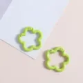 Close-up van lichtgroene bloemveerringen, legering DIY tassen hardware bedels accessoires. - Groen