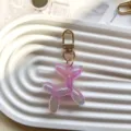 Close-up detail of a cute iridescent purple balloon dog keychain with gold hardware. - Purple Jelly Balloon Dog
