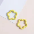 Close-up van gele bloemveerklikhaakjes voor DIY-sleutelhangers, tassen en telefoonbedels. - Geel