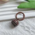 Detailed close-up of brown metal bell pendant with spring ring charm for DIY bag accessories. - Brown Spring Buckle + Bell