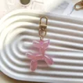 Detailed close-up shot of a cute pink jelly balloon dog keychain charm on a white ribbed tray. - Pink Jelly Balloon Dog