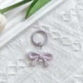 Paarse strik sleutelhanger detailopname, schattige tasbedel hanger met metalen accessoires. - Paarse strik met veergesp