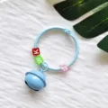 Detailansicht des DIY Metall Ring Schlüsselanhängers mit blauer Glocke und Buchstabenperlen. - Kartenring Glocken Anhänger / Hellblau