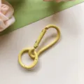 Gele metalen veersluiting haak en ronde ring sleutelhanger DIY sieraden accessoire detail. - Gele kalebas-sluiting en veerring