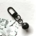 Dettaglio del portachiavi in metallo nero con moschettore girevole e campanello da 14mm. - Nero
