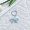 Close-up detail view of the light blue UV plated bow keychain charm with spring clasp. - Blue Bowknot & Spring Ring Clasp