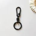 Close-up view of the black zinc alloy spring keychain featuring smooth rebound mechanism details. - Black Hanging Clasps