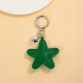 Close-up detail van de groene lederen ster-sleutelhanger met metalen ring en schattige belhanger. - Groen