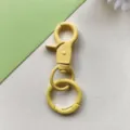 Dettaglio hardware metallico per portachiavi con moschettone giallo per accessori borse. - Moschettone giallo e anello a molla da 24 mm