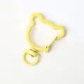 Close-up van de gele berenachtige draaibare musketonhaak, DIY legering sleutelhanger accessoire. - Beer met Veerring Sluiting / Geel
