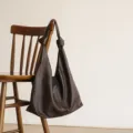 Brown leather hobo bag, soft cowhide shoulder bag with knotted strap, minimalist style. - Coffee