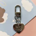 Metal heart keychain pendant detail, smooth electroplated finish, cute accessory for bags. - Silver