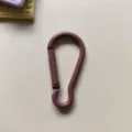 Detail shot of purple metal gourd carabiner spring snap hook, DIY bag charm accessory. - Brown