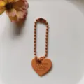 Oranje hartvormige kogelketting hanger sleutelhanger, gedetailleerd overzicht reliëftekst. - Oranje hartbedel met 12 mm ballketting