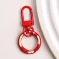 Rode metalen karabijnhaak sleutelhanger detailweergave met glanzende verf en leuk hangertje. - Rode donut veerringslot en karabijnsluiting