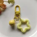 Gele acryl ster vormige sleutelhanger met metalen sluiting en hangende bel detail. - Gele veersluiting met 14 mm belletje en ster