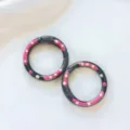 Close-up detail of black metal spring rings with colorful drip oil polka dot DIY jewelry accessories. - Black Donut Spring Clasp