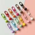 Portachiavi con moschettone in metallo colorato e campanelli per borse e accessori. - Multicolore