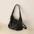 Minimalist black leather shoulder bag, large capacity soft hobo bag for daily commuting. - Black