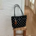 Black polka dot tote bag detail view, casual shoulder handbag with charm and spacious interior. - Black