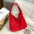 Détail de sac porté épaule en suédine rouge avec texture velours et large bandoulière mode. - Rouge