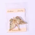 Dettaglio spilla ali d'angelo dorate con strass, elegante accessorio per maglioni. - Ali di Angelo (W837) / Oro