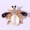 Exquisite gold-plated rhinestone bee brooch featuring purple enamel wings and white opal abdomen. - Deep purple