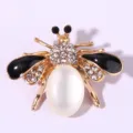 Detailed close-up of a charming rhinestone bee brooch featuring crystal details and enamel wings. - Black