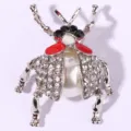 Rhinestone pearl beetle brooch detailed close-up showing intricate crystal inlay design. - White