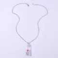 Clear glass wishing bottle pendant necklace featuring a dried pink flower and silver chain. - Necklace