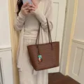 Primo piano dettagliato della borsa tote in pelle intrecciata marrone stile casual. - Marrone