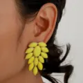 Detail shot of yellow acrylic rhinestone earrings, exaggerated leaf design, chic style. - Yellow