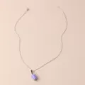 Close-up of the delicate boba tea cup pendant on a fine silver-tone chain necklace detail. - Purple