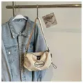 Detailaufnahme einer lässigen Canvas-Umhängetasche mit Kordelzug, an Kleiderständer hängend. - Khaki