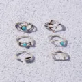 Close-up view of bohemian silver ring set featuring turquoise stones and geometric designs. - One Size / Antique Silver