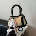 Detailed shot of canvas handbag with black leather trim, lace ribbon and heart pendant. - With Charm Style / Black With Pendant